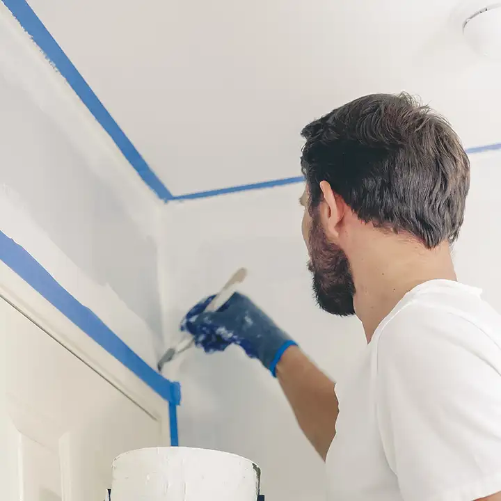 Professional Painter painting the edges of installed drywall in residential home - O'Fallon, IL