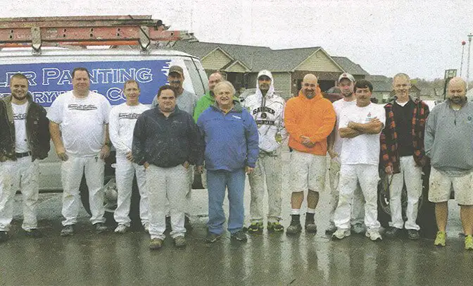 Tyler Painting and Drywall Co. team posing in front of company vehicles - O'Fallon, IL